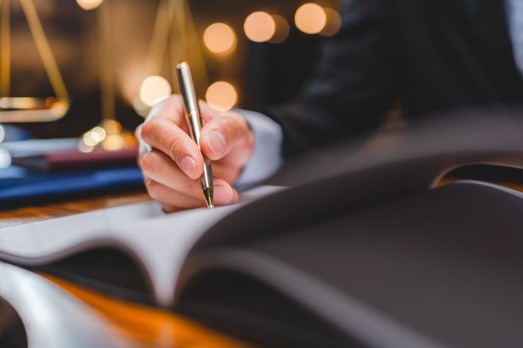 a hand holding a pen over documentations