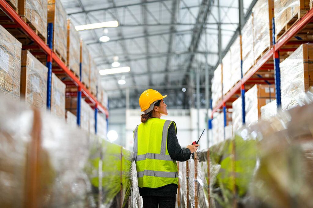 warehouse worker walking through warehouse aisle
