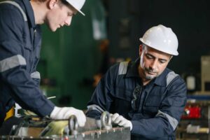 two factory workers working on injection moldings